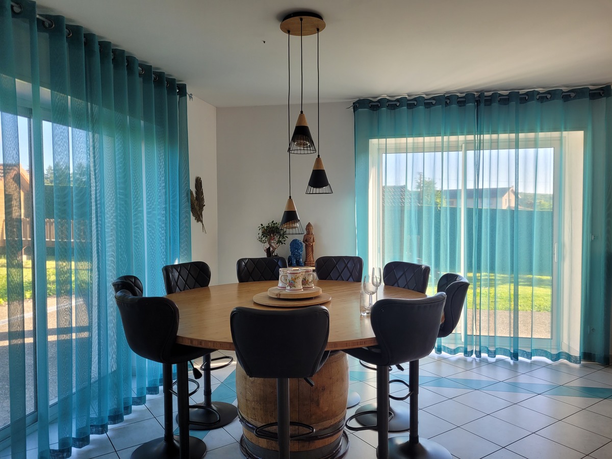 Salle lumineuse décorée avec des voilages bleus sur mesure aux normes anti-feu M1, réalisés par la couturière d’ameublement Muz'Art Déco à Bourgoin-Jallieu.